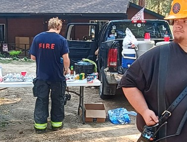 two local firefighters at potluck table after a fire